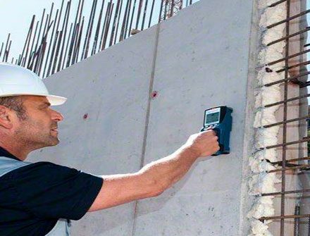 Técnico utilizando escáner estructural sobre un muro de concreto armado